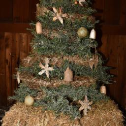 Add a touch of country charm to your holiday decor with a Christmas tree featuring a hay bale base and rustic ornaments.