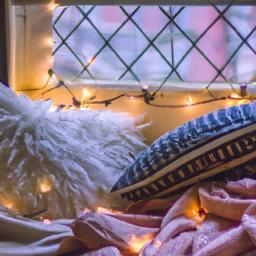 Create a cozy nook by your window with plush pillows, blankets, and fairy lights.
